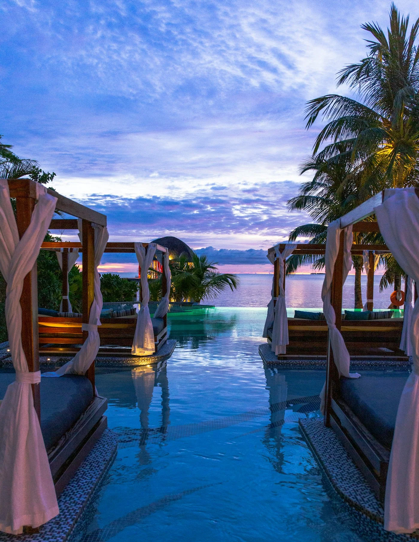 A softly lit pool and wellness space at dusk